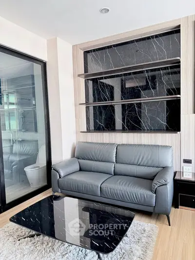 Modern living room with sleek black marble accents and plush gray sofa