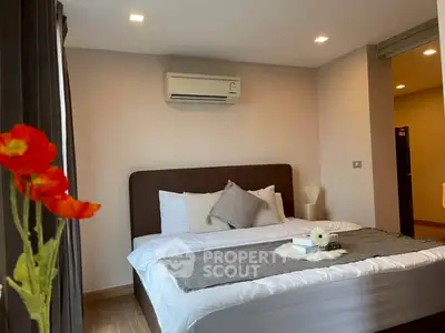 Modern bedroom with cozy bed, air conditioning, and elegant decor in a stylish apartment.