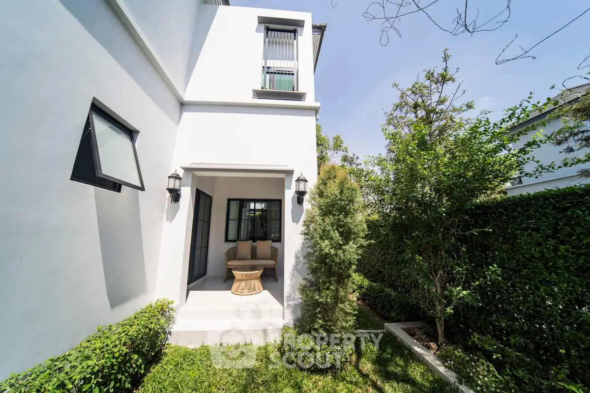 Charming modern home exterior with lush garden and cozy patio area.