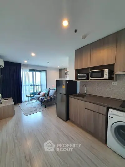 Modern open-plan living room and kitchen with balcony view in stylish apartment