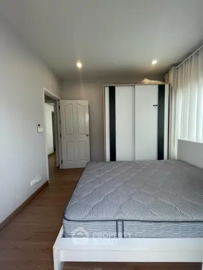 Spacious bedroom with modern wardrobe and natural light