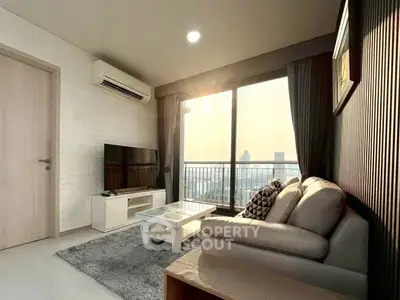 Modern living room with city view, featuring cozy sofa, TV, and large window for natural light.