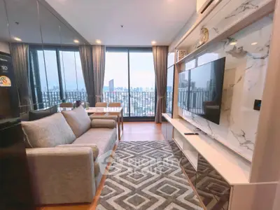 Modern living room with city view, stylish decor, and large windows for natural light.