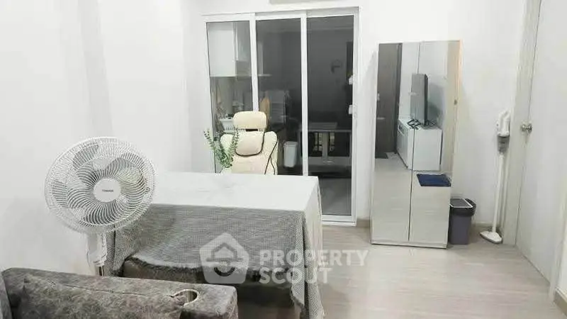 Modern living room with sleek furniture and mirrored wardrobe in a cozy apartment.