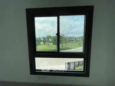 Modern window with scenic view of suburban neighborhood and lush greenery.