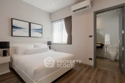 Modern bedroom with ensuite bathroom, featuring sleek design and natural light.