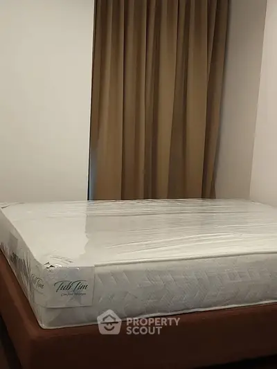 Spacious bedroom with a new mattress and elegant curtains, perfect for restful nights.