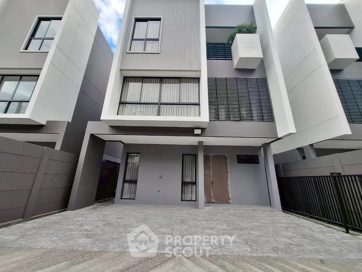 Modern multi-story townhouse with sleek facade and spacious driveway