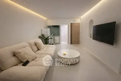 Modern living room with cozy sofa and wall-mounted TV in minimalist design.