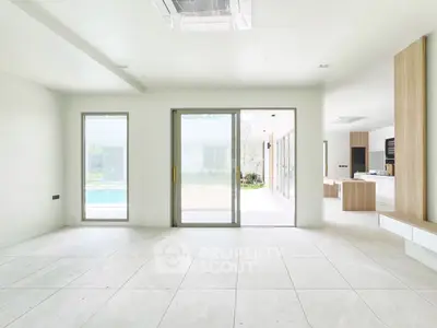 Spacious modern living room with pool view and open kitchen layout