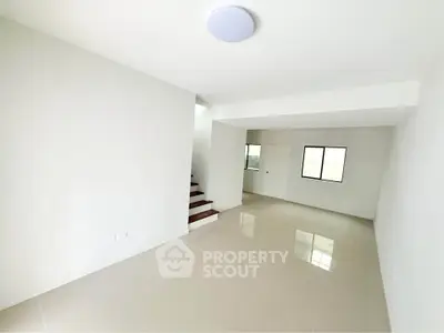 Spacious and bright living room with modern staircase and large windows