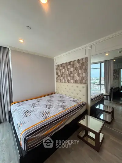Spacious bedroom with modern decor and large windows offering city views.