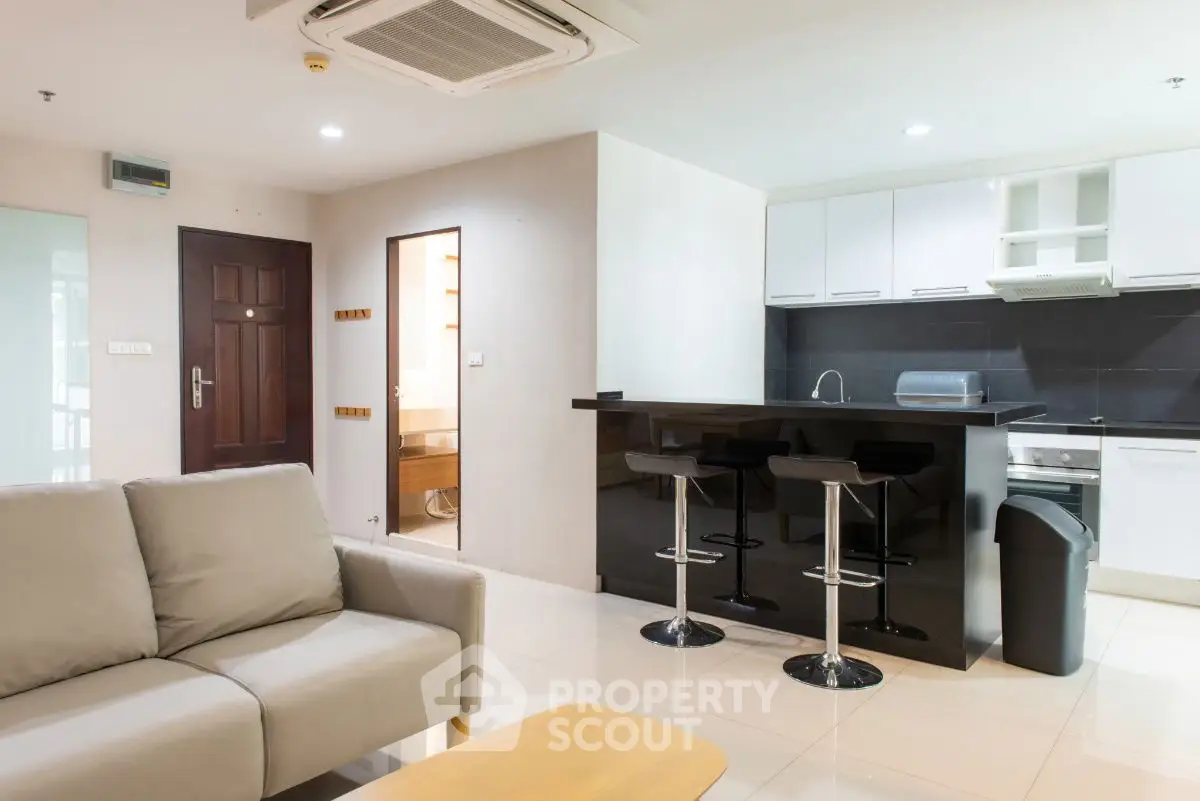 Modern open-plan living room with sleek kitchen and bar seating