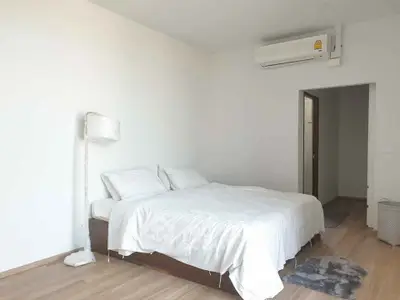 Spacious minimalist bedroom with modern air conditioning and cozy lighting