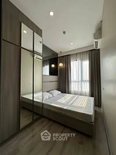 Modern bedroom with large mirrored wardrobe and natural light
