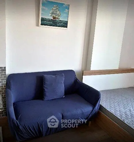 Cozy living area with a blue sofa and nautical wall art, perfect for relaxation.