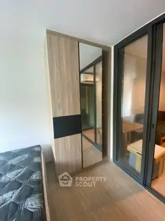 Modern bedroom with sleek wardrobe and large window for natural light.