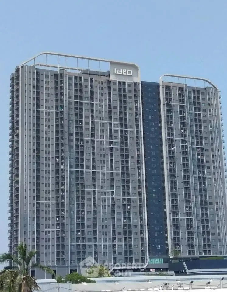 Modern high-rise residential building with sleek design and numerous windows, ideal for urban living.