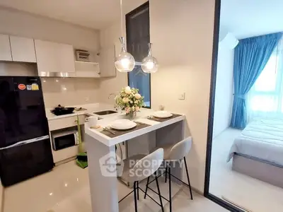 Modern open kitchen with breakfast bar and adjacent cozy bedroom