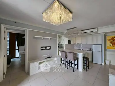 Modern open-layout kitchen with elegant chandelier and sleek appliances