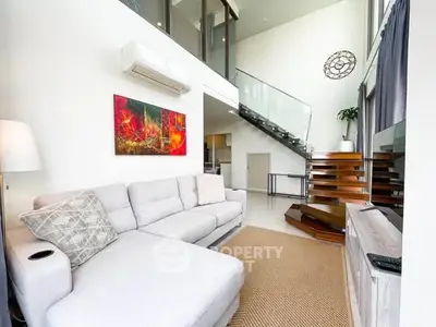 Spacious modern living room with high ceilings and stylish staircase