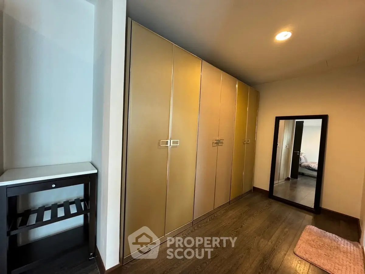 Spacious bedroom with ample closet space and elegant wood flooring.