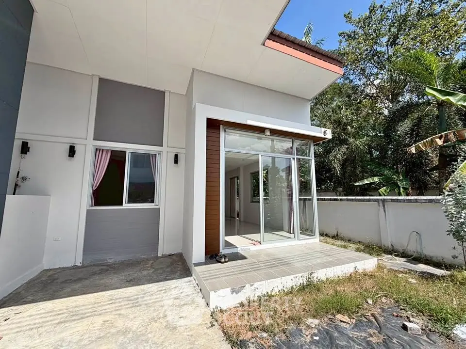 Modern single-story home with large glass doors and a small patio area.