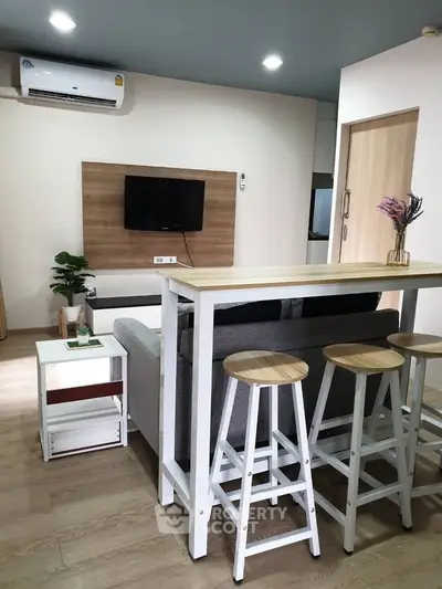 Modern living room with stylish bar seating and wall-mounted TV, perfect for cozy gatherings.