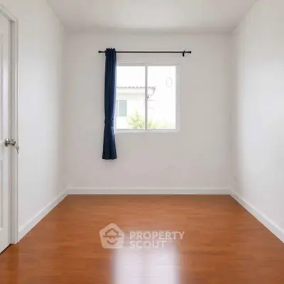 Spacious empty room with wooden flooring and large window, perfect for customization.