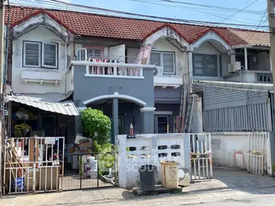 Charming townhouse with unique facade and potential for renovation in a vibrant neighborhood.