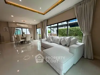 Spacious modern living room with large windows and elegant dining area, perfect for family gatherings.
