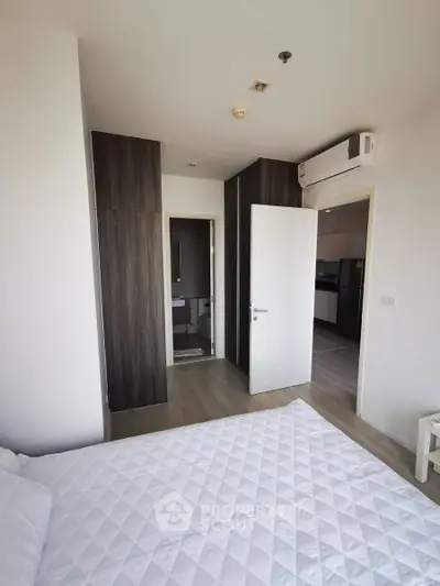 Modern bedroom with sleek design, featuring built-in wardrobe and air conditioning, perfect for urban living.