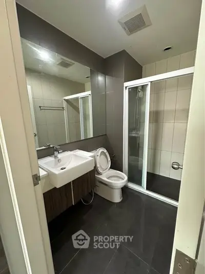 Modern bathroom with sleek design featuring a glass shower and stylish vanity.