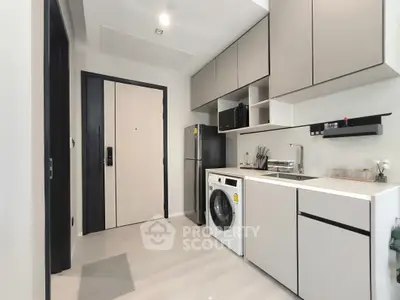 Modern compact kitchen with sleek cabinetry and built-in appliances in a stylish apartment.