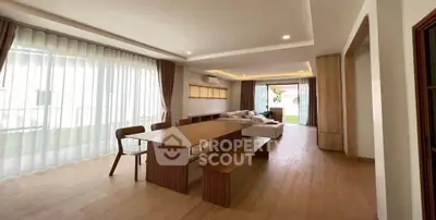 Spacious modern living room with wooden flooring and large windows.