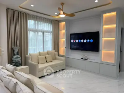 Elegant living room with modern decor and large TV, featuring cozy sofas and stylish lighting.