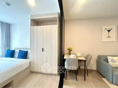 Modern studio apartment with cozy bedroom and dining area, featuring stylish decor and natural light.