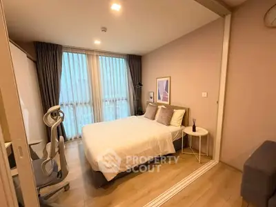 Cozy bedroom with modern decor and large window offering natural light.