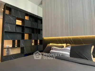 Modern bedroom with stylish black marble accent wall and cozy bedding