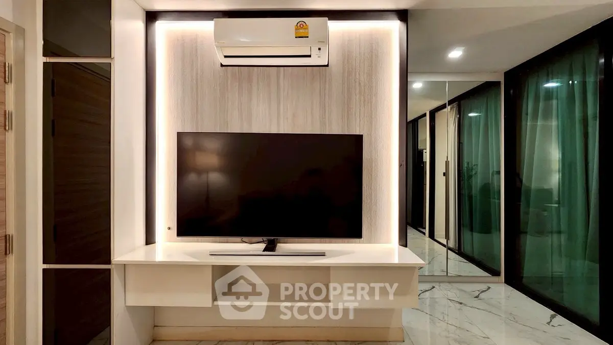 Modern living room with sleek TV setup and air conditioning unit