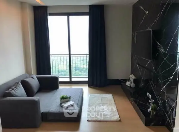 Modern living room with sleek black marble wall and large window view.