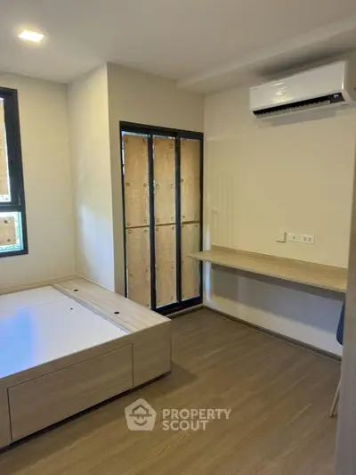 Modern bedroom with built-in desk and air conditioning in a minimalist design.