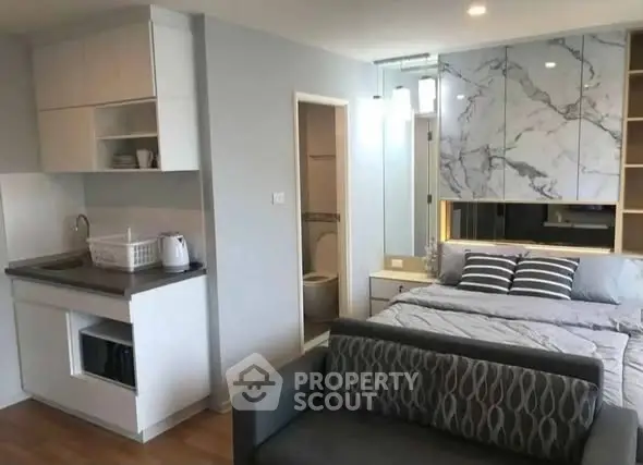 Modern studio apartment with compact kitchen and cozy bedroom