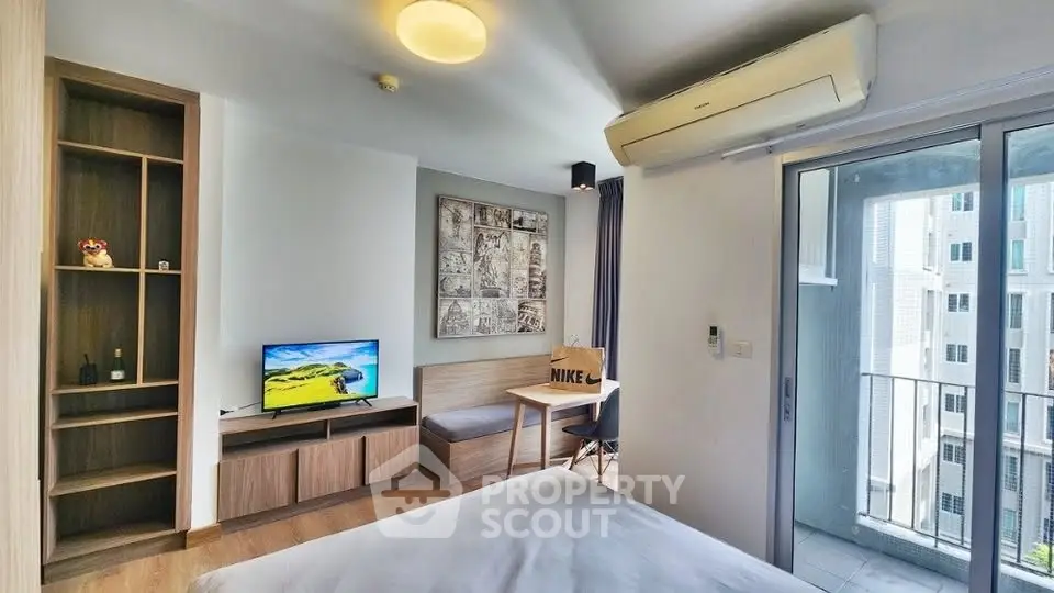 Modern studio apartment with balcony and stylish decor in urban setting.