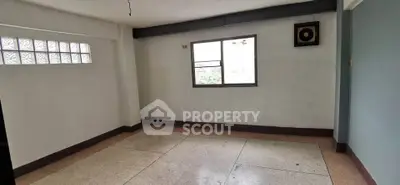 Spacious empty room with large window and tiled floor, ideal for customization.