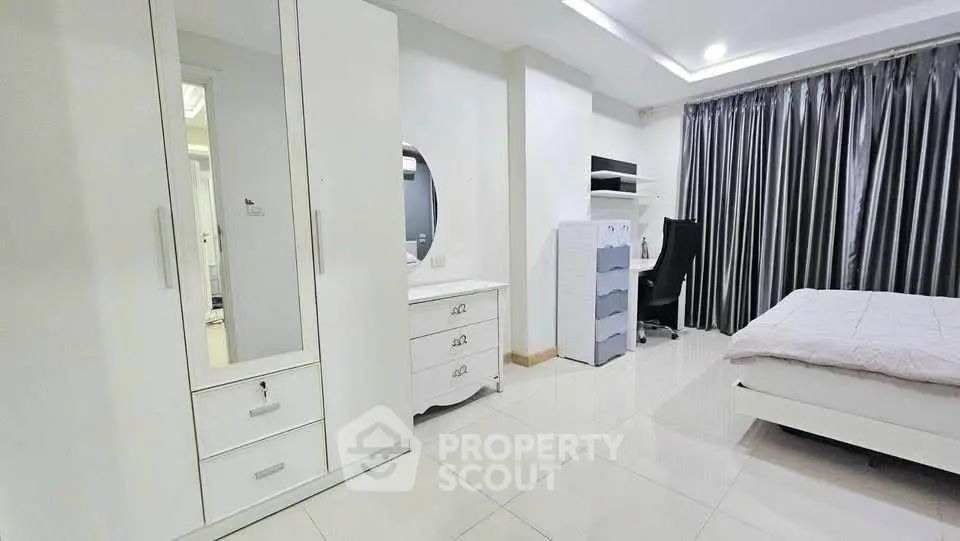 Spacious modern bedroom with sleek white furniture and elegant decor