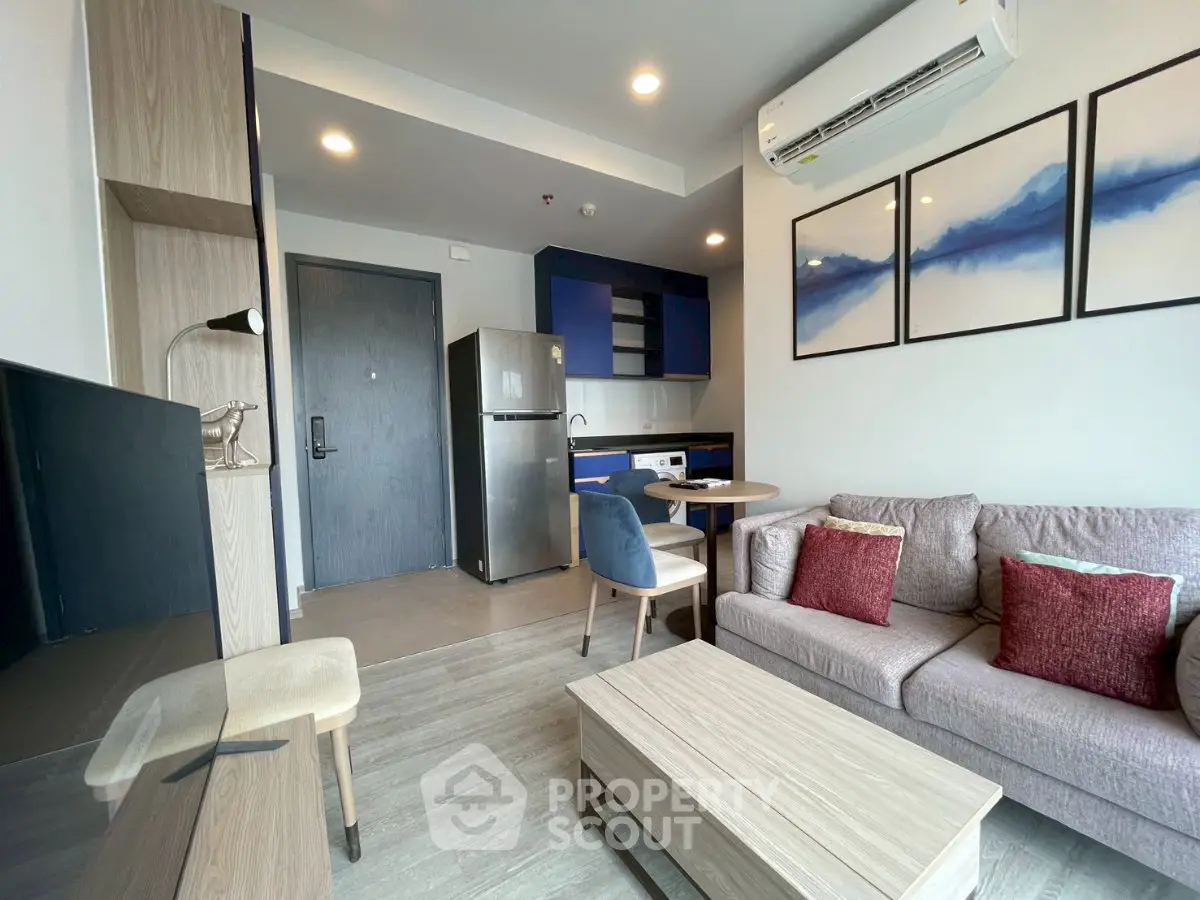 Modern living room with stylish furniture and open kitchen layout in a cozy apartment.