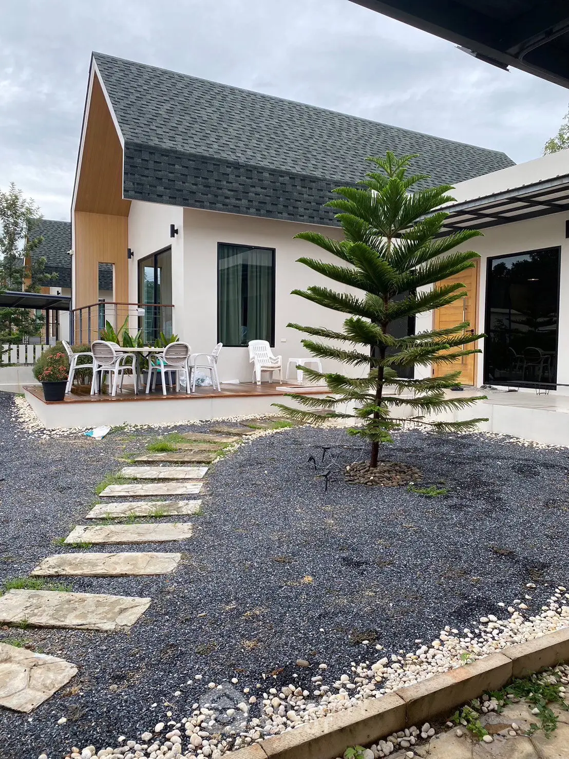 Charming modern house with unique roof design and inviting outdoor patio area.