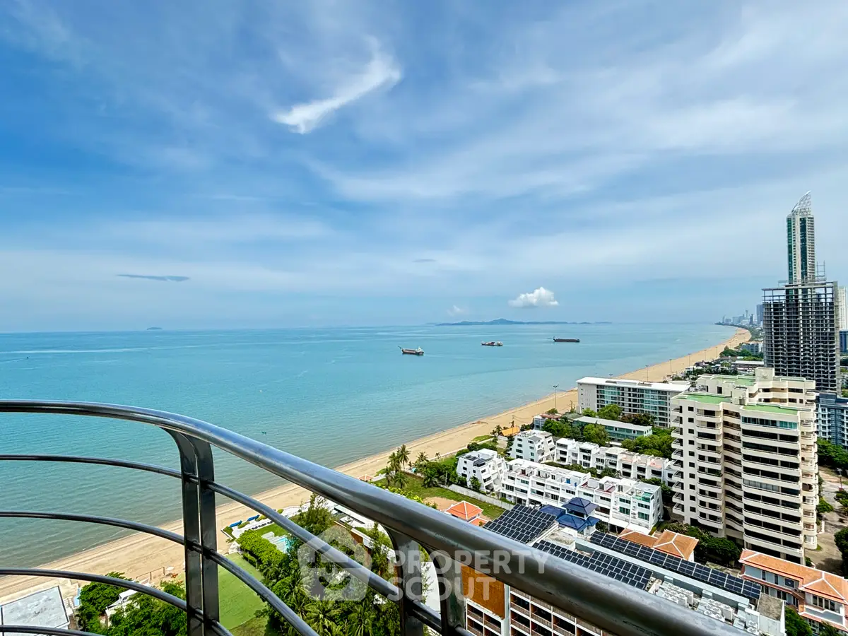 Stunning beachfront view from high-rise balcony overlooking ocean and cityscape.
