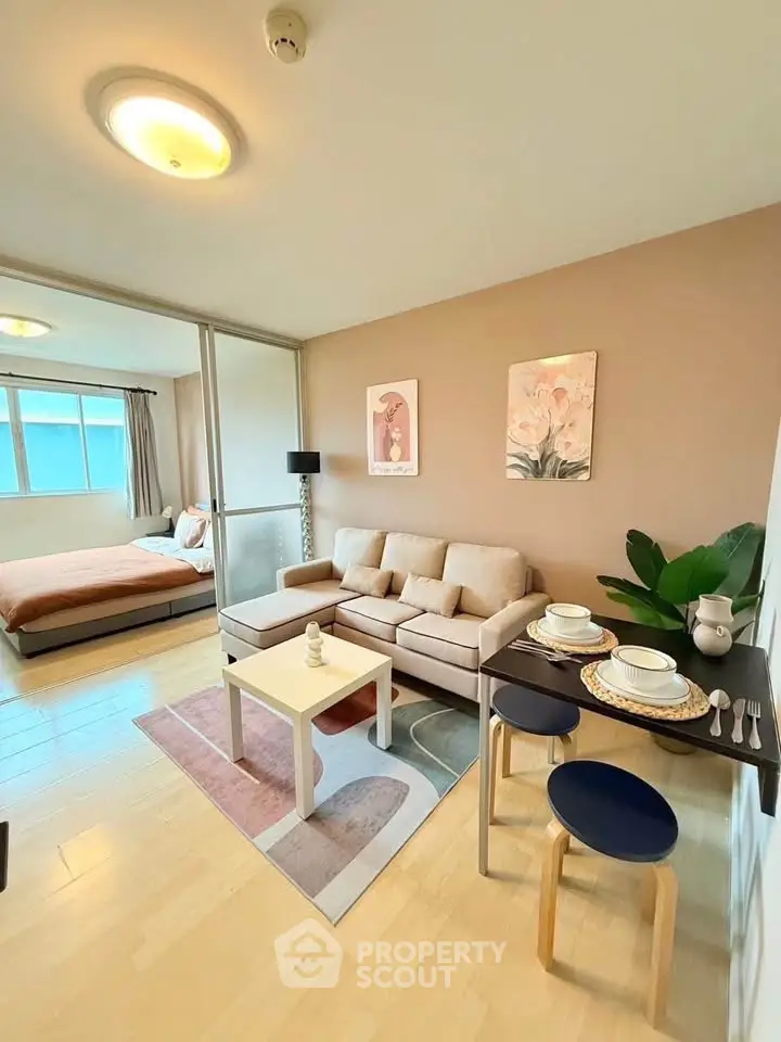 Modern open-plan living room with cozy seating and dining area, adjacent to a stylish bedroom.